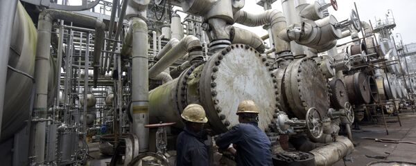 A picture taken on September 16, 2015 shows workers trying to tie a pipe of the first refinery in Nigeria, which was built in 1965 in oil rich Port Harcourt, Rivers State A picture taken on September 16, 2015 shows workers trying to tie a pipe of the first refinery in Nigeria, which was built in 1965 in oil rich Port Harcourt, Rivers State - Sputnik International