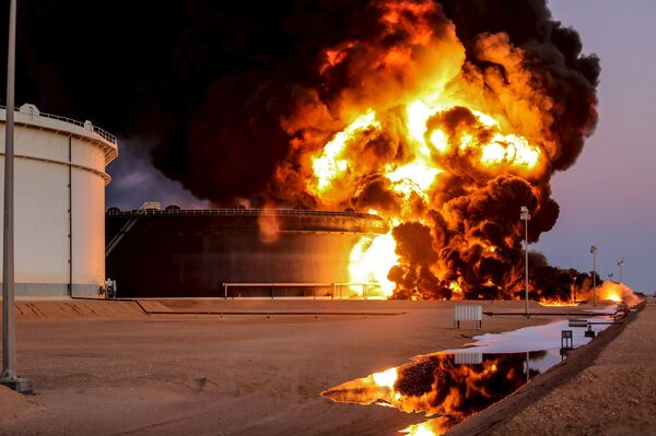 Fire rises from an oil tank in the port of Es Sider, in Ras Lanuf, Libya, in this file picture taken January 4, 2016.  - Sputnik International