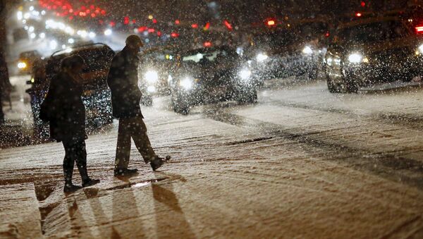People cross a street as it snows in Washington - Sputnik International