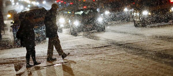 People cross a street as it snows in Washington - Sputnik International