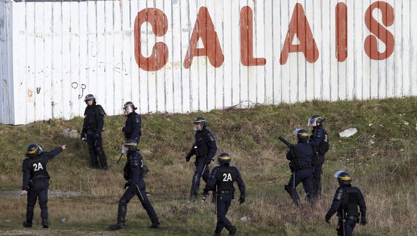 Police officers look for migrants attempting to access the Channel Tunnel in Calais, northern France, Thursday, Jan.21, 2016 - Sputnik International