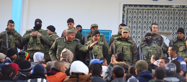An army soldier tries to disperse protesters as he stands guard with his comrades outside the local government office during a protest in Kasserine, Tunisia January 22, 2016. - Sputnik International