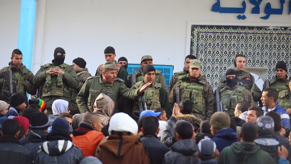 An army soldier tries to disperse protesters as he stands guard with his comrades outside the local government office during a protest in Kasserine, Tunisia January 22, 2016. - Sputnik International