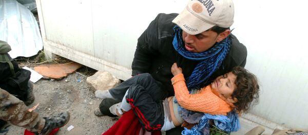 A child is comforted as Iraqi security forces help trapped civilians to come out to safe places in Ramadi, 70 miles (115 kilometers) west of Baghdad, Iraq, Thursday, Dec. 31, 2015. - Sputnik International