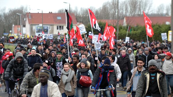People take part in a demonstration to support migrants who live in a migrant camp on the edge of town, nicknamed the Jungle on January 23, 2016 in the French port city of Calais, northern France. - Sputnik International