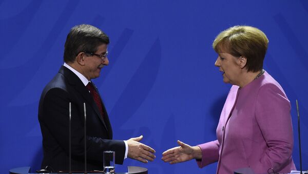 German Chancellor Angela Merkel (R) and Turkish Prime Minister Ahmet Davutoglu (L) shake hands during the press conference, after a meeting at the Chancellery, in Berlin on January 22, 2016 - Sputnik International