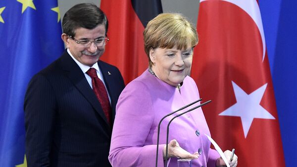 Turkish Prime Minister Ahmet Davutoglu and German Chancellor Angela Merkel arrive for a news conference after a meeting at the Chancellery in Berlin on January 22, 2016. - Sputnik International