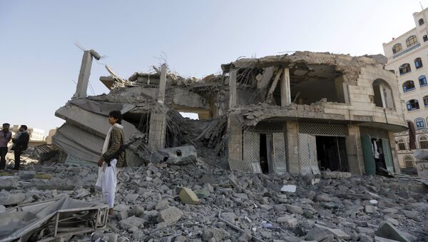 Houthi militant stands guard outside the house of court judge Yahya Rubaid after a Saudi-led air strike destroyed it, killing him, his wife and five other family members, in Yemen's capital Sanaa January 25, 2016 - Sputnik International