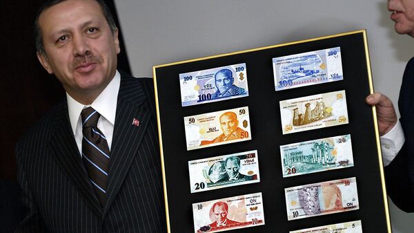 Turkish Prime Minister Recep Tayyip Erdogan holds a board featuring the new Turkish lira samples (File) - Sputnik International