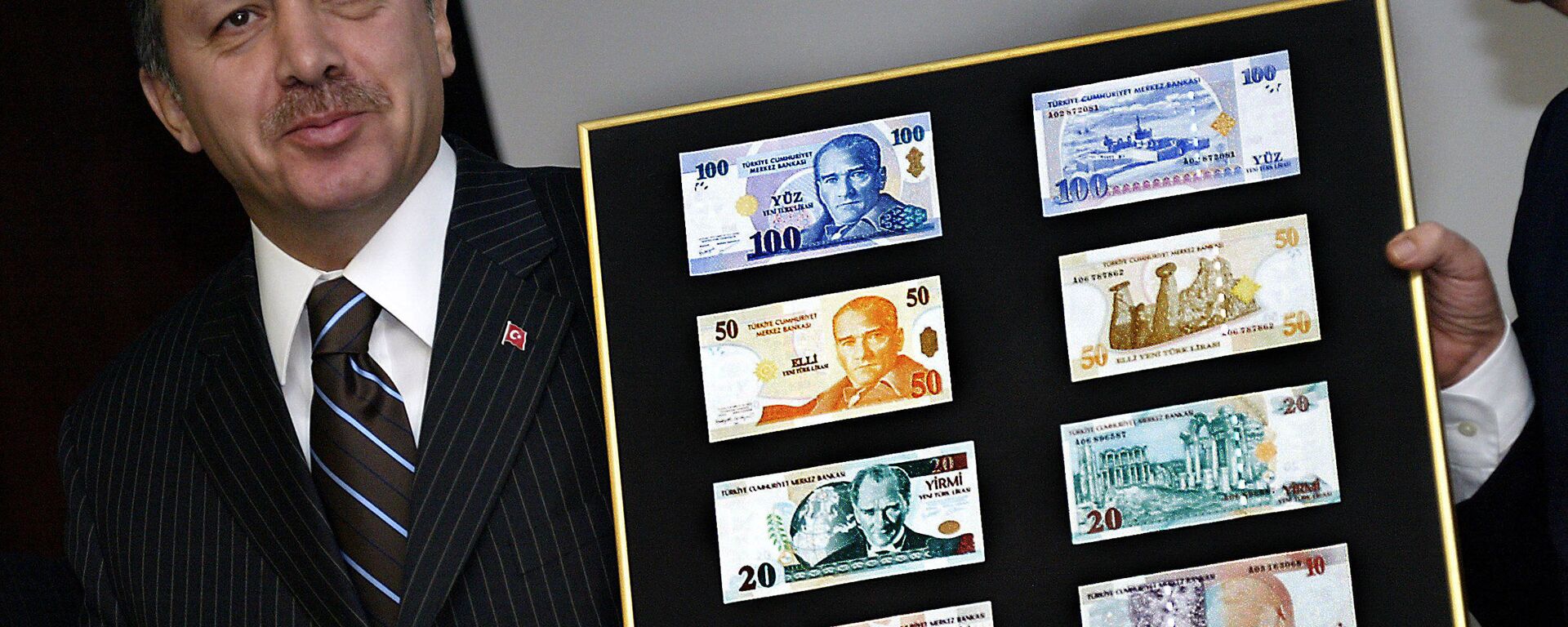Turkish Prime Minister Recep Tayyip Erdogan holds a board featuring the new Turkish lira samples (File) - Sputnik International, 1920, 31.12.2021