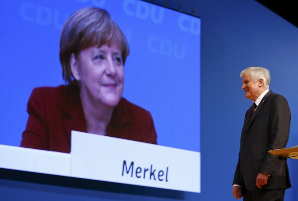 German Chancellor and leader of the Christian Democratic Union (CDU) Angela Merkel is seen on a video screen as Bavarian Prime Minister and head of the Christian Social Union (CSU) Horst Seehofer makes a speech at the CDU party congress in Karlsruhe, Germany in this December 15, 2015. German Chancellor and leader of the Christian Democratic Union (CDU) Angela Merkel is seen on a video screen as Bavarian Prime Minister and head of the Christian Social Union (CSU) Horst Seehofer makes a speech at the CDU party congress in Karlsruhe, Germany in this December 15, 2015. - Sputnik International