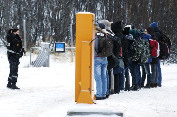 Migrants receive instructions from a Norwegian police officer at Storskog boarder crossing station near Kirkenes, after crossing the boarder between Norway and Russia on November 16, 2015 - Sputnik International