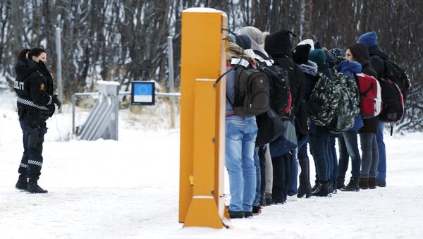 Migrants receive instructions from a Norwegian police officer at Storskog boarder crossing station near Kirkenes, after crossing the boarder between Norway and Russia on November 16, 2015 - Sputnik International