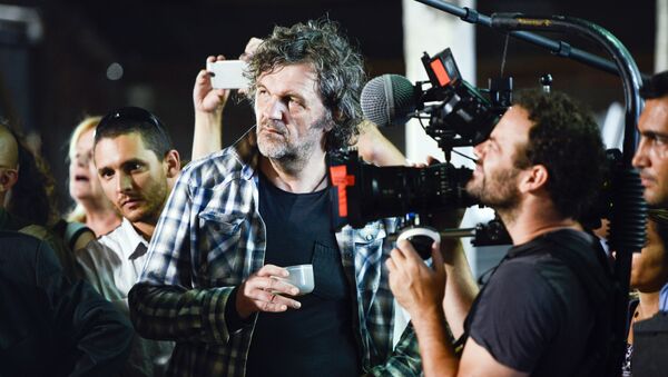 Serbian filmmaker Emir Kusturica, center, stands next to a cameraman while documenting the inauguration of an agricultural trade school that borders the family farm of former President Jose Mujica, on the outskirts of Montevideo, Uruguay, Thursday, March 5, 2015 - Sputnik International
