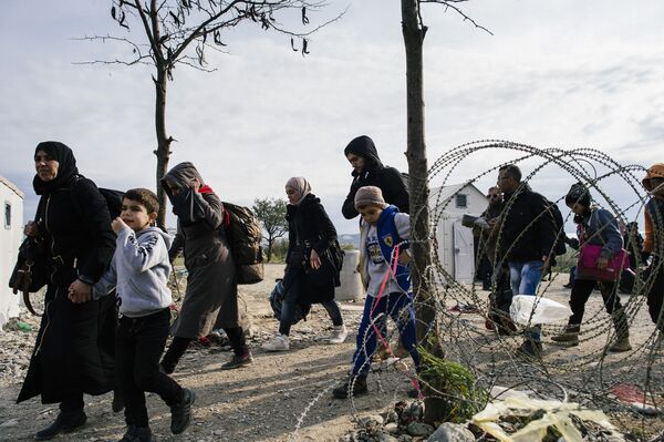 Migrants and refugees cross the Greek-Macedonian border near Gevgelija on November 15, 2015 - Sputnik International
