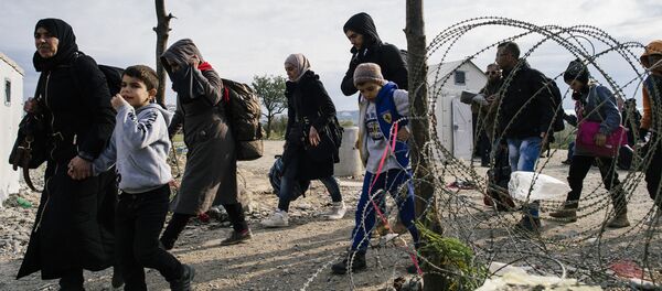 Migrants and refugees cross the Greek-Macedonian border near Gevgelija on November 15, 2015 - Sputnik International