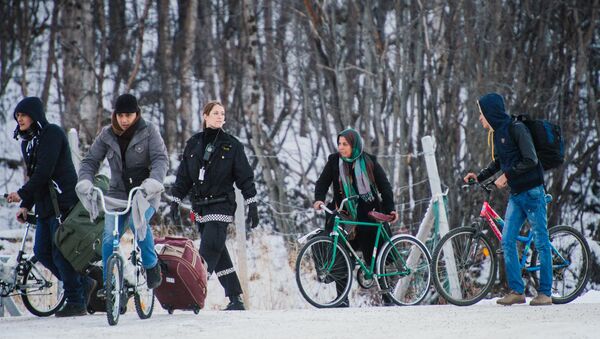 Refugees walk alongside there bikes to the Norwegian border crossing station at Storskog after crossing the border from Russia on November 12, 2015 near Kirkenes - Sputnik International