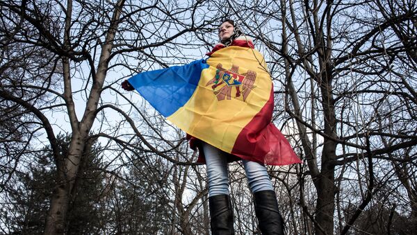 A participant in an opposition rally in Chisinau wrapped in Moldova's national banner - Sputnik International