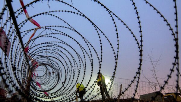 Workers take measurements of a near finished section of a 3,7 km long fence at a border crossing between Austria and Slovenia at Spielfeld, Austria on December 9, 2015. - Sputnik International