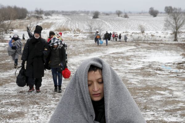 Migrants walk through a frozen field after crossing the border from Macedonia, near the village of Miratovac, Serbia, January 18, 2016. Migrants walk through a frozen field after crossing the border from Macedonia, near the village of Miratovac, Serbia, January 18, 2016. - Sputnik International
