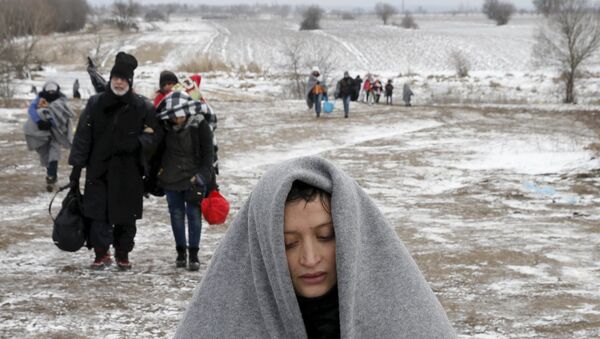 Migrants walk through a frozen field after crossing the border from Macedonia, near the village of Miratovac, Serbia, January 18, 2016. - Sputnik International