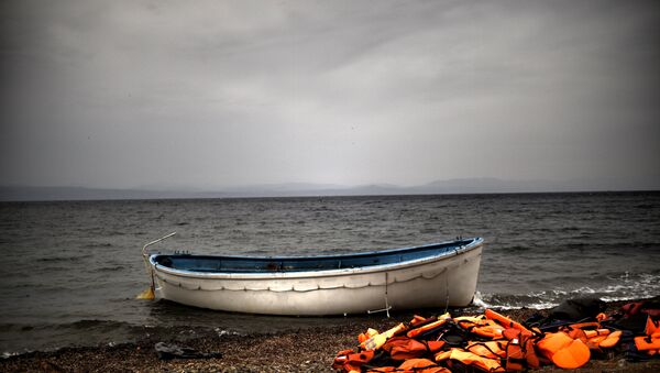Life jackets and a boat that were used by refugees and migrants to cross the Aegean Sea from Turkey lie abandoned on a beach on the Greek Island of Lesbos on 8 October 2015. - Sputnik International