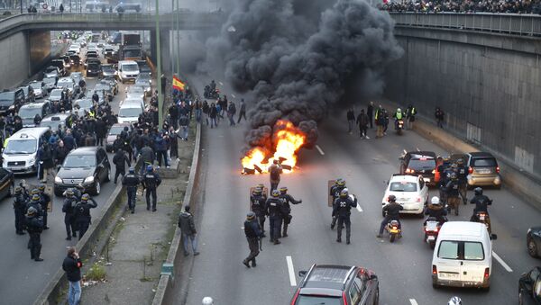 Anti-riot policemen arrive as taxi drivers block the traffic with a fire during a demonstration against the VTC (transport vehicle with chauffeur) on January 26, 2016 on the ringroad (peripherique) at porte Maillot in Paris - Sputnik International