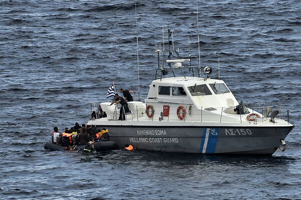 Hellenic coast guard personnel rescue refugees and migrants on a dinghy as they try to reach the Greek island of Lesbos while crossing the Aegean sea from Turkey on September 29, 2015 Hellenic coast guard personnel rescue refugees and migrants on a dinghy as they try to reach the Greek island of Lesbos while crossing the Aegean sea from Turkey on September 29, 2015 - Sputnik International
