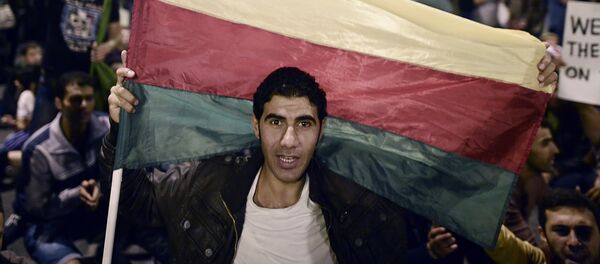 A man holds the flag of the Syrian Kurdish Democratic Union Party (PYD) as Kurds living in Greece protest in central Athens on October 8, 2014 - Sputnik International