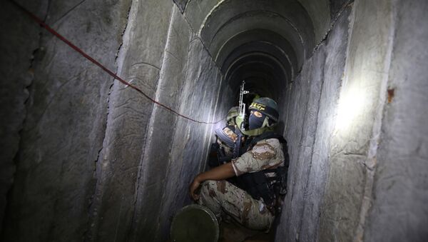 Palestinian militants from the Islamic Jihad's armed wing, the Al-Quds Brigades, squat in a tunnel, used for storing weapons, as they take part in military training in the south of the Gaza Strip on March 3, 2015 - Sputnik International