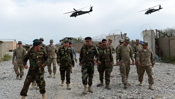 US army and Afghan National Army (ANA) soldiers walk as a NATO helicopter flies overhead - Sputnik International