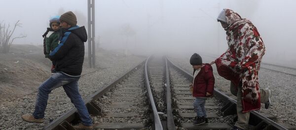 Migrants cross the railway tracks as they wait to cross the Greek-Macedonian border near the village of Idomeni, Greece, January 28, 2016 - Sputnik International