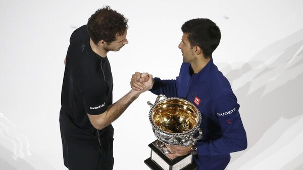 Serbia's Novak Djokovic (R) shakes hands with Britain's Andy Murray while holding the men's singles trophy after winning their final match at the Australian Open tennis tournament at Melbourne Park, Australia - Sputnik International