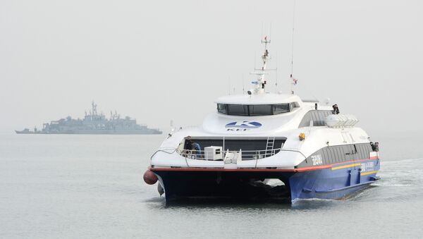 A passenger ferry arrrives with a war ship in the background at the South Korea-controlled island of Yeonpyeong near the disputed waters of the Yellow Sea - Sputnik International
