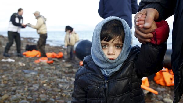 A Syrian refugee child looks on, moments after arriving on a raft with other Syrian refugees on a beach on the Greek island of Lesbos, January 4, 2016. - Sputnik International