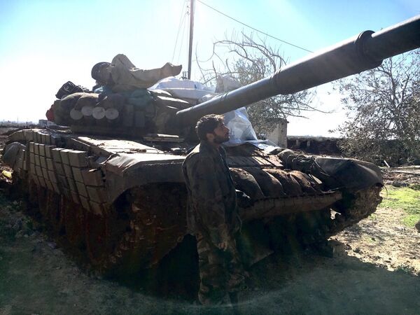 Syrian Arab Army soldier stands near a T72 tank in the town of Al-Shaykh Maskin in the Daraa province liberated from terrorists Syrian Arab Army soldier stands near a T72 tank in the town of Al-Shaykh Maskin in the Daraa province liberated from terrorists - Sputnik International