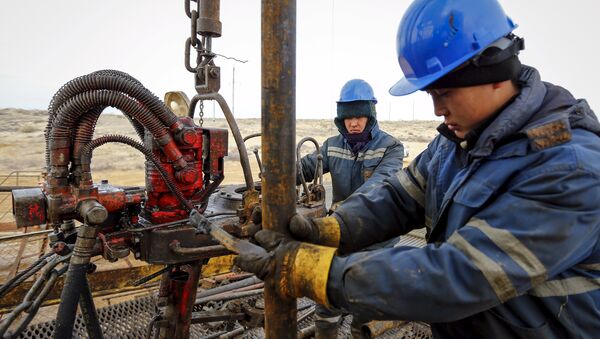 Workers carry out maintenance at an oil well on oil fields operated by a subsidiary of the KazMunayGas Exploration Production JSC in Kyzylorda region, southern Kazakhstan, January 21, 2016 - Sputnik International