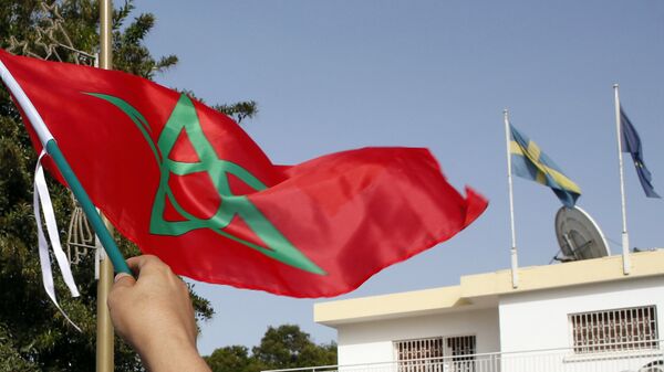 Moroccan woman waves her national flag outside the Swedish Embassy in Rabat, Morocco, as hundreds of protesters stage a protest against Sweden’s diplomatic position on Moroccan-controlled Western Sahara, Sunday, Oct. 4, 2015 - Sputnik International