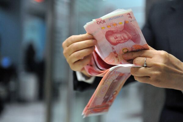 A bank employee counts 100-yuan banknotes at a bank in Hangzhou, east China's Zhejiang province on December 1, 2015. A bank employee counts 100-yuan banknotes at a bank in Hangzhou, east China's Zhejiang province on December 1, 2015. - Sputnik International