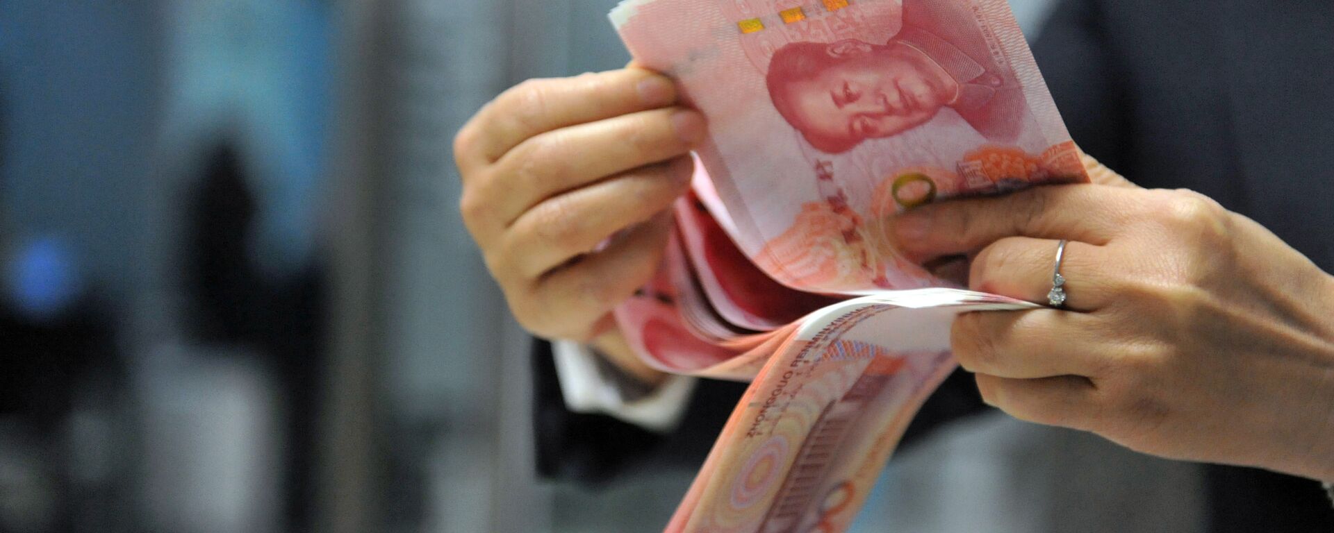 A bank employee counts 100-yuan banknotes at a bank in Hangzhou, east China's Zhejiang province on December 1, 2015. - Sputnik International, 1920, 30.03.2023