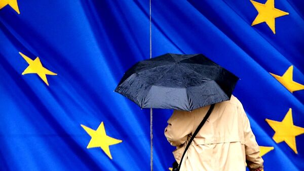 A woman carrying an umbrella walks towards the European Commission headquarters in Brussels, Belgium February 2, 2016. - Sputnik International
