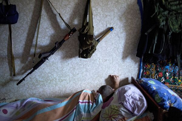 A member of a rapid response unit rests in a barrack before a curfew patrol in Lugansk A member of a rapid response unit rests in a barrack before a curfew patrol in Lugansk - Sputnik International
