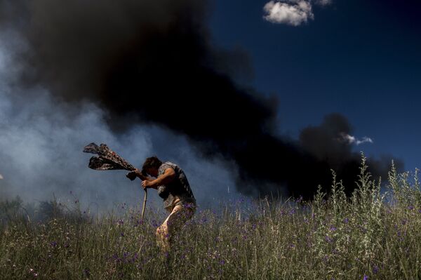 A local resident near a car that was hit during shelling of Lugansk - Krasnodon highway by Ukrainian armed forces. Photo by Valery Melnikov A local resident near a car that was hit during shelling of Lugansk - Krasnodon highway by Ukrainian armed forces. Photo by Valery Melnikov - Sputnik International