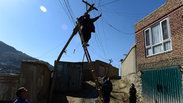 An Afghan electrician man repairs old power lines on a hillside in Kabul on March 1, 2014 - Sputnik International