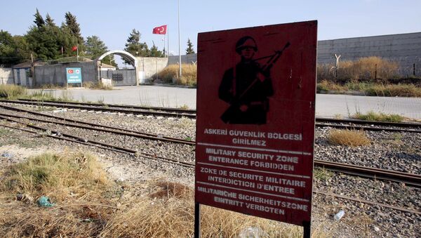 A Turkish military warning sign, with the closed Karkamis border gate in the background, is pictured in Karkamis, bordering with the Islamic State-held Syrian town of Jarablus, in Gaziantep province, Turkey, in this August 1, 2015 file photo - Sputnik International