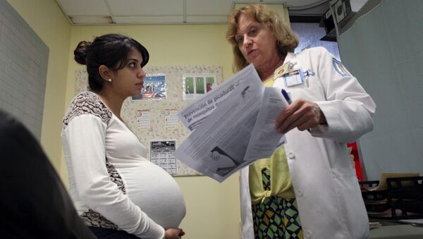 Nancy Trinidad, who is 32 weeks pregnant, listens to the explanation of a doctor about how to prevent Zika, Dengue and Chikungunya viruses at a public hospital in San Juan, Puerto Rico, February 3, 2016 - Sputnik International