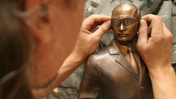 Russian artist Oleg Kukushkin working on a mini sculpture of Russian President Vladimir Putin - Sputnik International