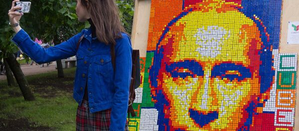 A girl takes a selfie against a portrait of Russian President Vladimir Putin composed of Rubik's Cubes at the festival of the social network VKontakte in St. Petersburg A girl takes a selfie against a portrait of Russian President Vladimir Putin composed of Rubik's Cubes at the festival of the social network VKontakte in St. Petersburg - Sputnik International