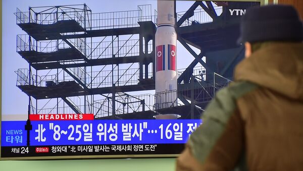 A man watches a news report on North Korea's planned rocket launch as the television screen shows file footage of North Korea's Unha-3 rocket which launched in 2012, at a railway station in Seoul on February 3, 2016 - Sputnik International