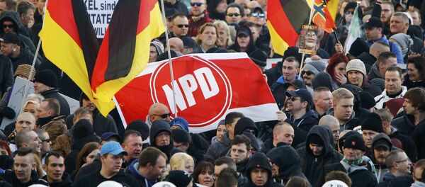 Supporters of anti-immigration right-wing movement PEGIDA (Patriotic Europeans Against the Islamisation of the West) hold up a banner with the logo of the far-right National Democratic Party (NPD) as they take part in in demonstration march, in reaction to mass assaults on women on New Year's Eve, in Cologne, Germany, January 9, 2016. Supporters of anti-immigration right-wing movement PEGIDA (Patriotic Europeans Against the Islamisation of the West) hold up a banner with the logo of the far-right National Democratic Party (NPD) as they take part in in demonstration march, in reaction to mass assaults on women on New Year's Eve, in Cologne, Germany, January 9, 2016. - Sputnik International